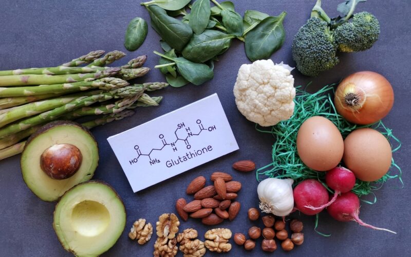 Foods shown that are rich in glutathione alongside a card that has glutathione written down