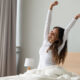 Happy woman waking up after a good night of sleep