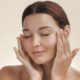 Up close image of model showing off her skin while touching her face