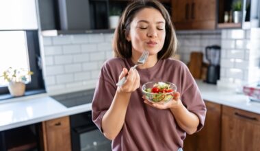 Young woman eating a small healthy meal in her kitchen