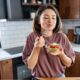 Young woman eating a small healthy meal in her kitchen
