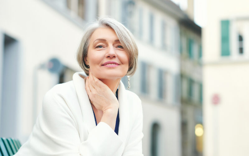 Close up outdoor photo of older woman with radiant skin