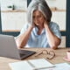 Tired and fatigued older woman sitting at her computer