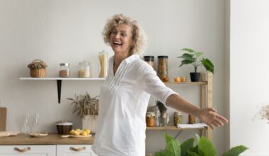Happy and cheerful older woman having fun at home and smiling with arms out