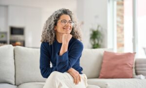 Happy and relaxed middle aged woman sitting on her couch
