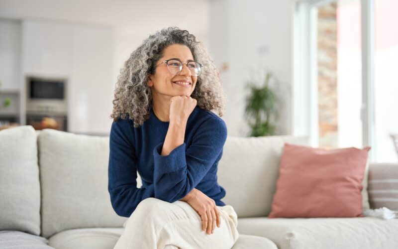 Happy and relaxed middle aged woman sitting on her couch