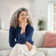 Happy and relaxed middle aged woman sitting on her couch