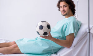 Young man staying in hospital in transfusion concept, IV therapy for athlets