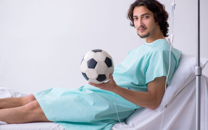 Young man staying in hospital in transfusion concept, IV therapy for athlets