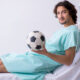 Young man staying in hospital in transfusion concept, IV therapy for athlets