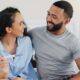 Happy couple, pregnancy stick and results in home, hug and support for positive baby news. People, plastic test and together for reading ovulation tool in bedroom, fertility treatment and embrace