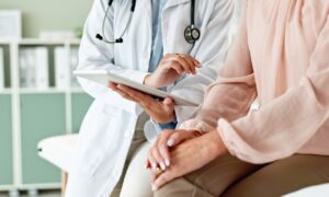 Pharmacist explaining medication to a patient while holding a prescription bottle, providing guidance on dosage and discussing liraglutide cost.