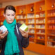 Woman in a pharmacy comparing two medication boxes, symbolizing patient decisions when choosing between semaglutide and liraglutide