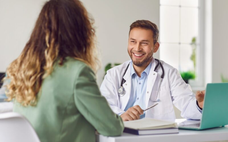 Smiling doctor consulting with a patient in his office, discussing treatment options and explaining the liraglutide maximum dose.