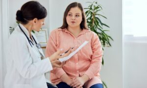 Doctor reviewing medical notes with a patient during consultation, evaluating whether she is a suitable liraglutide candidate for treatment.