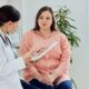 Doctor reviewing medical notes with a patient during consultation, evaluating whether she is a suitable liraglutide candidate for treatment.