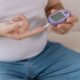 Diabetic senior man on wheelchair checking blood sugar level with fingerstick testing glucose meter. Elderly man with type 1 diabetes using blood glucose monitor at home. Acarbose and Metformin