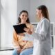 medicine, healthcare and people concept - female doctor with tablet pc computer talking to smiling woman patient at hospital