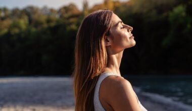 Young woman with long hair enjoying sun with closed eyes getting natural vitamin D outdoors. Peace of mind. Mindfulness, mental health, spirituality, well-being, unwind yourself. Sermorelin Dosage