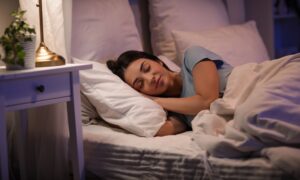 Beautiful young happy woman sleeping on bed in evening at home with sermorelin
