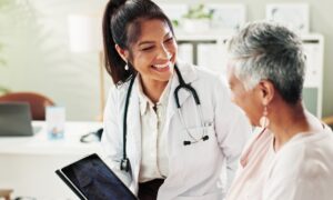 Smiling doctor discussing starting acarbose with a patient during a medical consultation.