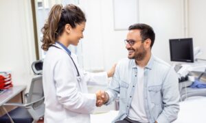 Wegovy smiling young female doctor shake hand close health insurance deal with elderly patient at consultation in hospital. Happy woman GP handshake greeting get acquainted with man in clinic.