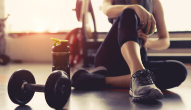 Woman tirzepatide exercise workout in gym fitness breaking relax holding apple fruit after training sport with dumbbell and protein shake bottle healthy lifestyle bodybuilding, Athlete builder muscles lifestyle.