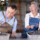An older couple smiling and laughing while working with clay at a pottery wheel, symbolizing creativity, vitality, and healthy aging supported by NAD+ therapy.
