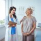 Smiling caring young female Wegovy nurse doctor caretaker assisting happy senior grandma helping old patient in rehabilitation recovery at medical checkup visit, elder people healthcare homecare concept