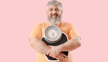Overweight happy mature man with scales on pink background. Weight loss with tirzepatide.