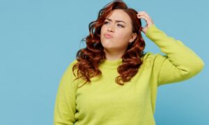 Young puzzled thoughtful confused chubby overweight plus size big fat fit woman wear green sweater look aside scratch head isolated on plain blue background studio portrait. People lifestyle concept Tirzepatide