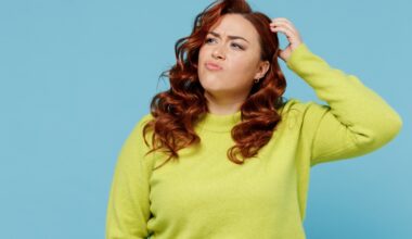Young puzzled thoughtful confused chubby overweight plus size big fat fit woman wear green sweater look aside scratch head isolated on plain blue background studio portrait. People lifestyle concept Tirzepatide