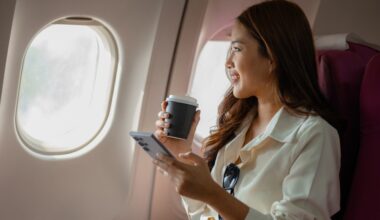 Woman traveling with tirzepatide, holding a coffee cup and phone while sitting on an airplane.