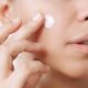 Woman applying Tretinoin into her skin to treat acne, wrinkles, and dark circles.
