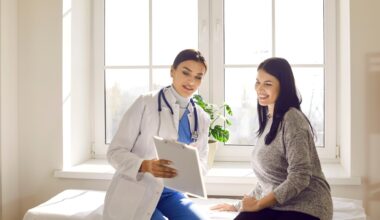 Female doctor sitting beside a smiling woman in a bright medical office, reviewing health information on a clipboard — representing patient guidance on managing acarbose side effects and improving comfort during diabetes treatment.