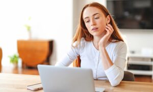 “Woman at home using a laptop, representing the convenience and accessibility of consulting a PCOS online doctor for faster diagnosis and personalized care.
