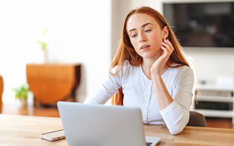 “Woman at home using a laptop, representing the convenience and accessibility of consulting a PCOS online doctor for faster diagnosis and personalized care.