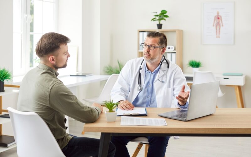 Doctor consulting with a patient in a bright medical office, representing professional guidance on combining Metformin and GLP-1 medications like semaglutide or tirzepatide for improved weight loss outcomes.