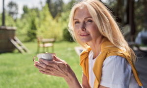 Confident middle-aged woman enjoying coffee outdoors, symbolizing balance and well-being during menopause, representing the discussion on GLP-1 medications and hormone replacement therapy (HRT) for weight management in women over 50.