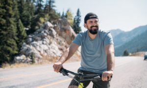 Energized man riding a bike in nature, representing the boost in energy, focus, and cellular vitality that NAD+ IV therapy may provide.