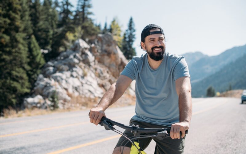 Energized man riding a bike in nature, representing the boost in energy, focus, and cellular vitality that NAD+ IV therapy may provide.