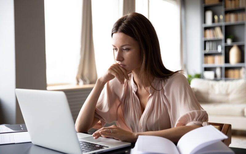 Focused woman researching on a laptop at home, representing someone exploring clinical updates and FDA timelines for new weight loss medications like retatrutide.