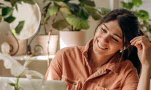 Woman enjoying increased energy and mental clarity while working on her laptop, symbolizing the lesser-known benefits of sermorelin such as improved mood, focus, and recovery.