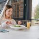 A happy woman enjoying a healthy salad and juice, representing mindful eating and making smart dietary choices while managing weight and balancing alcohol intake.