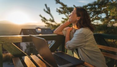 A happy woman sitting outdoors at a table with her laptop open, enjoying the fresh morning air while tracking her weight loss progress and lifestyle changes on Mounjaro (tirzepatide).