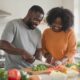 Black couple cooking healthy meal in kitchen to build their intimacy due to ozempic affecting their libido.