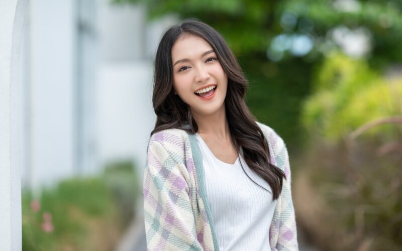 Smiling woman outdoors representing informed choices between peptides and dietary supplements for wellness