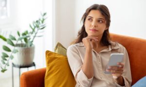 Woman deep in thought sitting on couch researching different weight loss pens and how they work