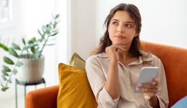 Woman deep in thought sitting on couch researching different weight loss pens and how they work
