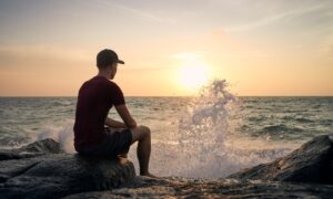 Man Sitting Next To Ocean And Contemplating What Does Weight Regain Look Like After Stopping Wegovy